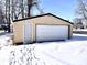 Garage exterior with overhead door, side door and snow covered yard at 210 S West St, Paragon, IN 46166
