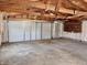 Inside the garage with unfinished ceiling and walls, white overhead door and concrete floor at 210 S West St, Paragon, IN 46166