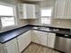 Bright kitchen featuring white cabinets, stainless steel dishwasher, and neutral backsplash at 210 S West St, Paragon, IN 46166