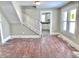 Living room with a staircase, hardwood floors, and a view of the kitchen, ready for renovation at 210 S West St, Paragon, IN 46166