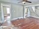 Living room with exposed hardwood floors, a ceiling fan, and views into connecting rooms at 210 S West St, Paragon, IN 46166