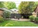 Beautiful backyard featuring a fire pit, chairs, wooden fence, and lush greenery at 219 Buckingham Dr, Indianapolis, IN 46208