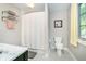Bright bathroom featuring a tiled floor, toilet, window, and shower with a curtain at 219 Buckingham Dr, Indianapolis, IN 46208