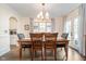 Dining room featuring a wooden table with seating for six, a chandelier, and french doors at 219 Buckingham Dr, Indianapolis, IN 46208