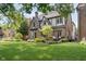 Attractive brick home with lush green lawn and mature trees, creating a welcoming ambiance at 219 Buckingham Dr, Indianapolis, IN 46208