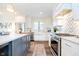 Well-lit kitchen with stainless steel appliances, farmhouse sink, and center island with barstools at 219 Buckingham Dr, Indianapolis, IN 46208