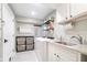 Well-lit laundry room with sink, folding rack, washer, dryer and storage baskets at 219 Buckingham Dr, Indianapolis, IN 46208