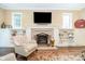 Cozy living room with fireplace, built-in shelves, a flat screen TV, and a comfortable chair at 219 Buckingham Dr, Indianapolis, IN 46208