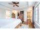 Cozy main bedroom featuring a tray ceiling, ceiling fan, closet and ensuite bath at 219 Buckingham Dr, Indianapolis, IN 46208