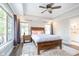 Tranquil main bedroom featuring a tray ceiling, ceiling fan, and views to the outside at 219 Buckingham Dr, Indianapolis, IN 46208