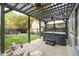 Outdoor patio area with a dark pergola, ceiling fans, a hot tub, and a view of the backyard at 219 Buckingham Dr, Indianapolis, IN 46208