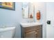 Cozy powder room with a wooden vanity, white sink, and modern fixtures at 219 Buckingham Dr, Indianapolis, IN 46208