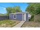 The backyard features a cute blue building with a metal fence around the lot at 2257 E Brookside Ave, Indianapolis, IN 46218
