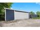 View of detached two car garage, featuring vinyl siding and a white overhead door at 2257 E Brookside Ave, Indianapolis, IN 46218