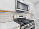 Modern kitchen features stainless steel appliances and white cabinets at 2257 E Brookside Ave, Indianapolis, IN 46218