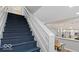 Open concept staircase leading to the kitchen and living area with grey wood floors at 2257 E Brookside Ave, Indianapolis, IN 46218