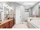 Bright bathroom featuring double vanity, tub, and tiled floors, perfect for relaxation at 2487 Wayward Wind Dr, Indianapolis, IN 46239