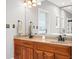 Bathroom featuring a double vanity with wood cabinets and decorative mirrors at 2487 Wayward Wind Dr, Indianapolis, IN 46239