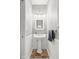 Stylish half bathroom featuring a pedestal sink, decorative mirror and wainscoting at 2487 Wayward Wind Dr, Indianapolis, IN 46239
