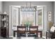 Dining area featuring an elegant light fixture, bay windows, and a dark wood table set for four at 2487 Wayward Wind Dr, Indianapolis, IN 46239