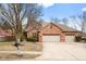 Charming brick home boasts a three-car garage and well-maintained landscaping at 2487 Wayward Wind Dr, Indianapolis, IN 46239