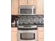 Well-lit kitchen with stainless steel microwave and oven, accented by dark countertops and mosaic backsplash at 2487 Wayward Wind Dr, Indianapolis, IN 46239