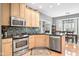 Bright kitchen features stainless steel appliances, light wood cabinets, and view to dining area at 2487 Wayward Wind Dr, Indianapolis, IN 46239