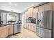 Spacious kitchen with stainless steel refrigerator, light wood cabinets, and a bay window at 2487 Wayward Wind Dr, Indianapolis, IN 46239