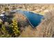 A beautiful aerial view of a peaceful blue pond surrounded by trees in a quiet neighborhood at 2487 Wayward Wind Dr, Indianapolis, IN 46239