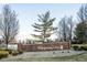 A welcoming brick sign for Whispering Pines community, surrounded by landscaping, offering a serene living environment with natural beauty at 2487 Wayward Wind Dr, Indianapolis, IN 46239