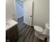 Bathroom featuring modern fixtures, gray wood-look flooring, and a white vanity at 2819 Walker Ave, Indianapolis, IN 46203