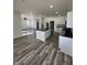 Open kitchen with an island, stainless steel appliances, modern white cabinets, and dark countertops at 2819 Walker Ave, Indianapolis, IN 46203