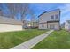 View of backyard with green grass, walkway to back of house, detached garage and neighbor's homes at 3238 Guilford Ave, Indianapolis, IN 46205