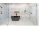 A stylish bathroom featuring a freestanding black tub, marble walls, dual shower heads and glass-enclosed shower at 3238 Guilford Ave, Indianapolis, IN 46205