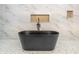 Modern bathroom features freestanding black tub, white and gold marble tile walls, and custom in-wall shelves at 3238 Guilford Ave, Indianapolis, IN 46205