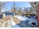 Back of house with detached garage and snowy back yard and sunny skies at 4139 N Grand Ave, Indianapolis, IN 46226