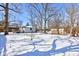 Backyard with snow, wooden fence, wooden shed, detached garage, and mature trees at 4139 N Grand Ave, Indianapolis, IN 46226