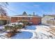 Back of a brick home with a door, bushes, some snow, and a sunny sky at 4139 N Grand Ave, Indianapolis, IN 46226