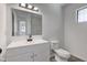 Modern bathroom features a white vanity, toilet, mirror, and a window for natural light at 4139 N Grand Ave, Indianapolis, IN 46226
