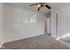 Comfortable bedroom featuring neutral carpet, white walls, a ceiling fan, and a view into the bathroom at 4139 N Grand Ave, Indianapolis, IN 46226