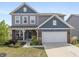Charming two-story home featuring a brick facade, gray siding, a well-manicured lawn, and an attached two-car garage at 4345 Indigo Walk Ln, Indianapolis, IN 46239