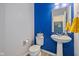 Bright powder room featuring blue accent wall, pedestal sink, and modern fixtures at 4345 Indigo Walk Ln, Indianapolis, IN 46239