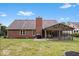 Brick home featuring a brick chimney and a large enclosed sunroom, complete with a patio and grill at 4524 Moss Creek Ter, Indianapolis, IN 46237