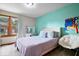 Comfortable bedroom with window and a turquoise accent wall, creating a relaxing atmosphere at 4524 Moss Creek Ter, Indianapolis, IN 46237