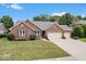 Charming brick home featuring an attached two car garage, manicured lawn, and tasteful landscaping at 4524 Moss Creek Ter, Indianapolis, IN 46237