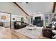 Inviting living room boasts vaulted ceilings, hardwood floors, a cozy fireplace, and comfortable leather seating at 4524 Moss Creek Ter, Indianapolis, IN 46237