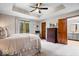 Serene main bedroom with tray ceilings, carpet, and a view of the backyard at 4524 Moss Creek Ter, Indianapolis, IN 46237