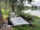 Relaxing backyard featuring a swing under a tree, a stone garden, and views of a peaceful pond in a charming community at 520 Gatewood Dr, Greenwood, IN 46143