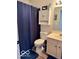 Well-lit bathroom featuring a vanity, toilet, and shower with a navy blue shower curtain at 520 Gatewood Dr, Greenwood, IN 46143