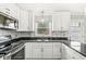 Well-lit kitchen with white cabinetry, black countertops, and stainless steel appliances at 5465 Leone Dr, Indianapolis, IN 46226